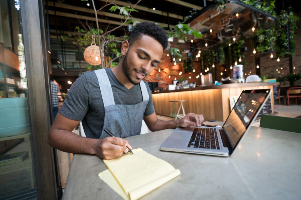 Happy man doing the books at a restaurant